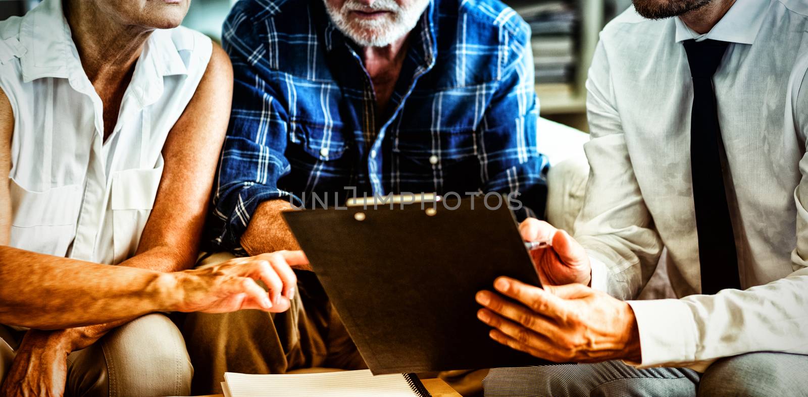 Senior couple planning their investments with financial advisor in living room