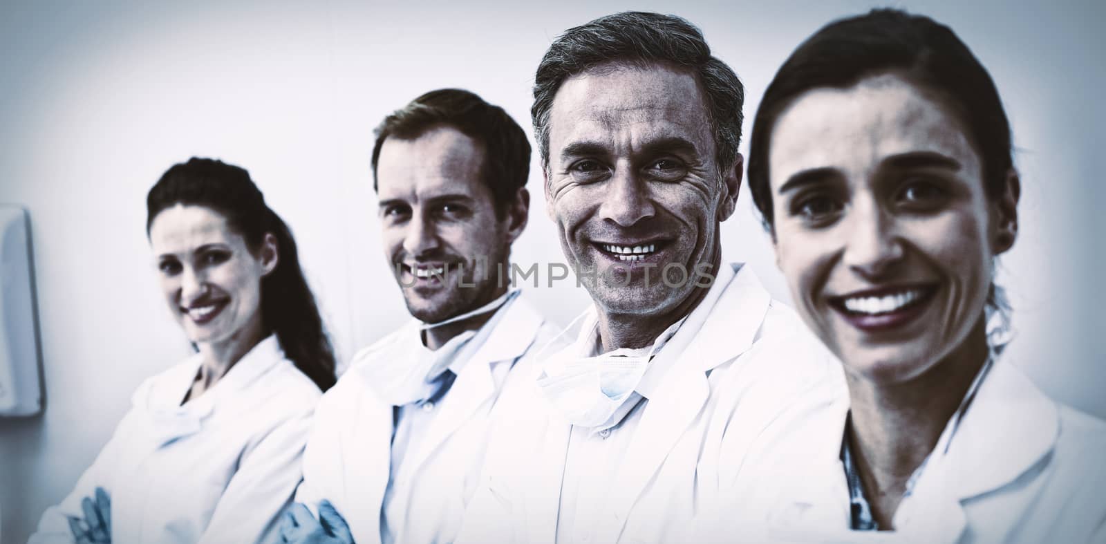 Portrait of smiling dentists standing with arms crossed in dental clinic