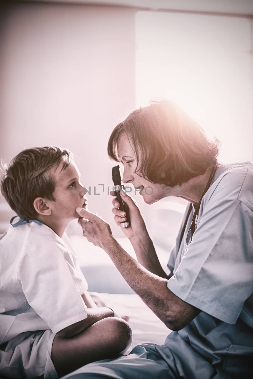 Female doctor examining patient with ophthalmic device by Wavebreakmedia