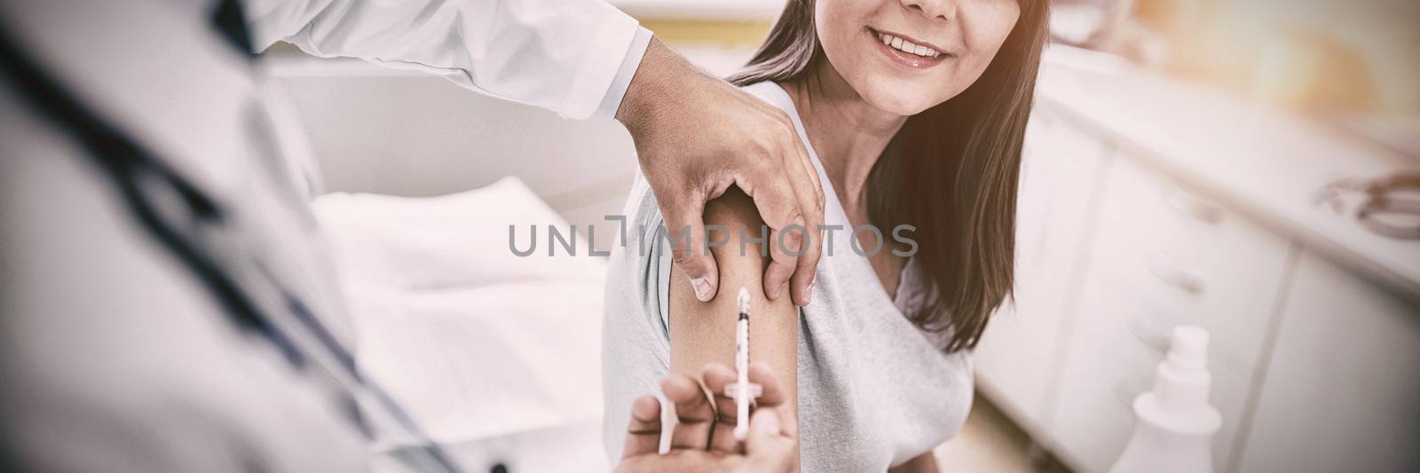 Doctor giving an injection to the patient at hospital