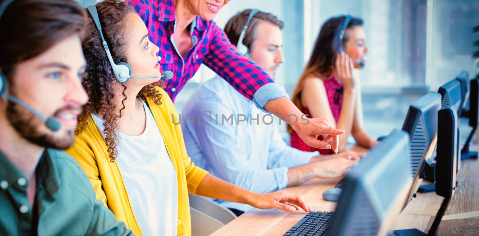 Customer service executive trainer assisting her team at office