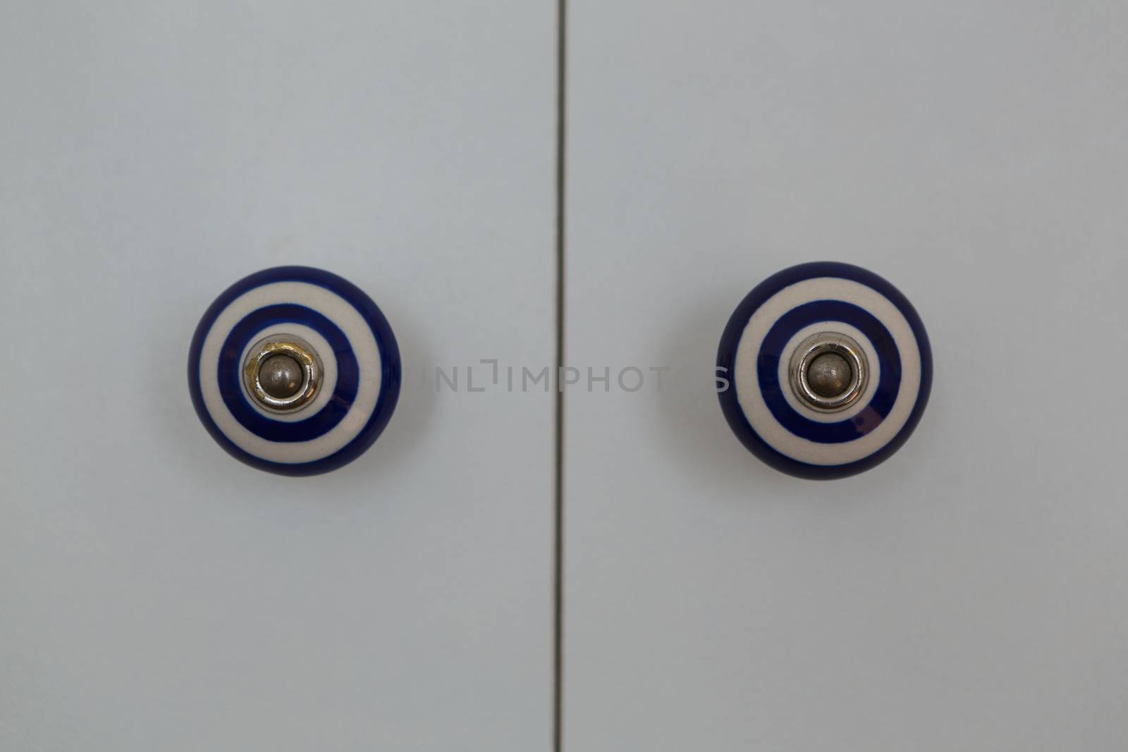 Front close-up view of a closed white modern door of cabinet at home