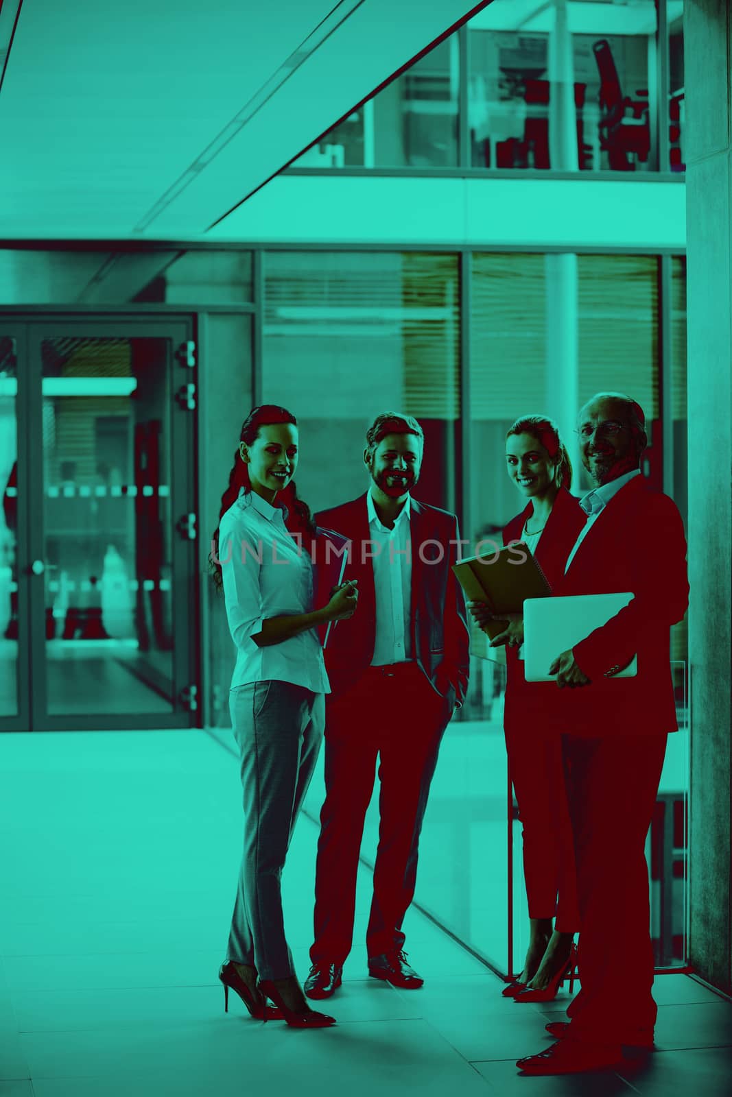 Happy businesspeople standing in office corridor by Wavebreakmedia