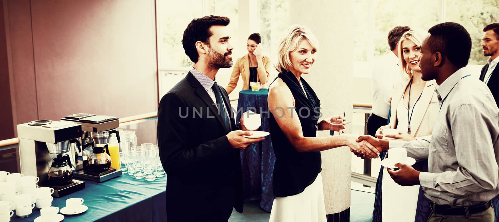 Business executives interacting with each other while having coffee at conference center