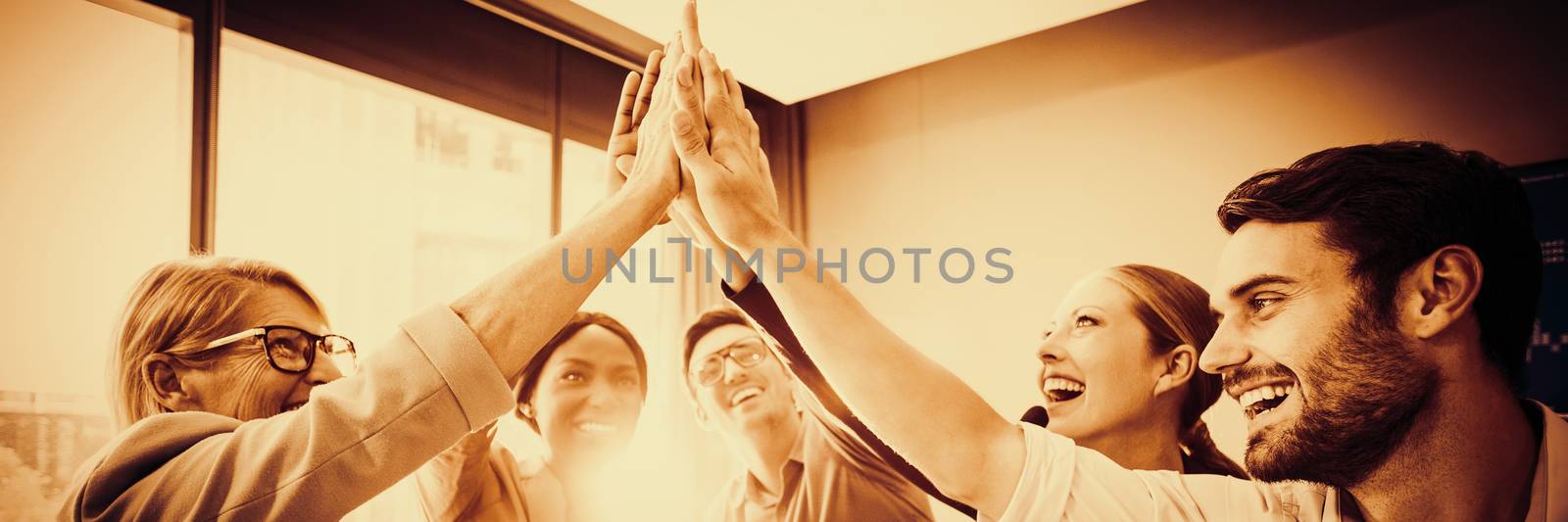 Business people giving high five at desk in the office