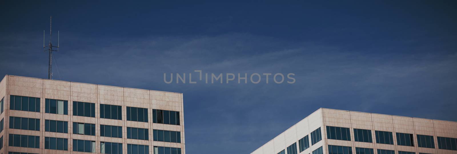View of office buildings against blue sky  by Wavebreakmedia