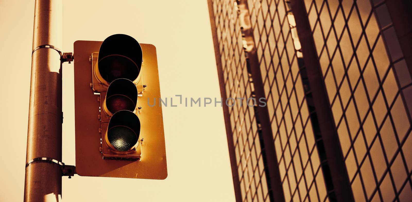 Traffic light with office in the background  by Wavebreakmedia