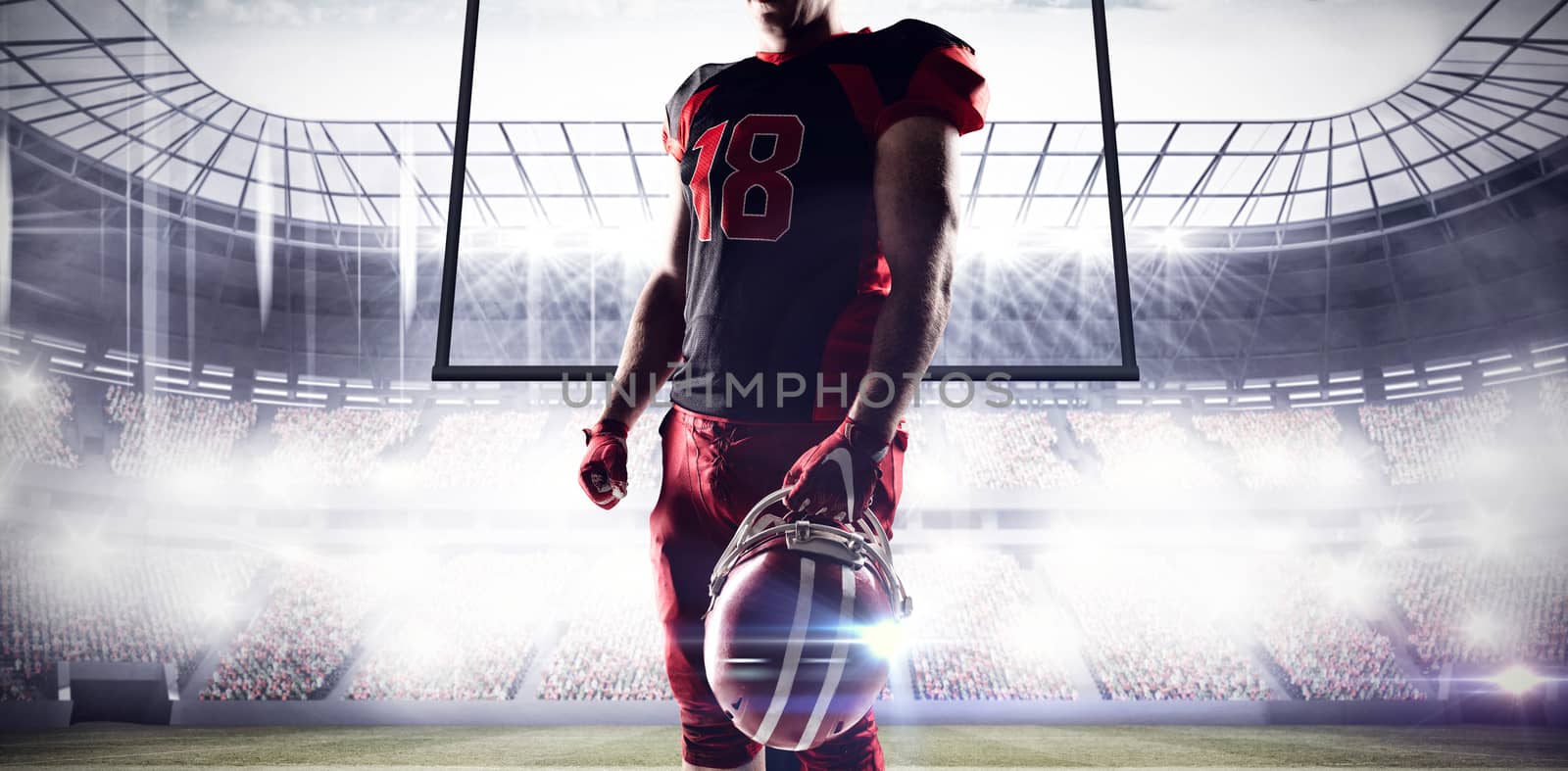 Volleyball player holding rugby helmet against football arena