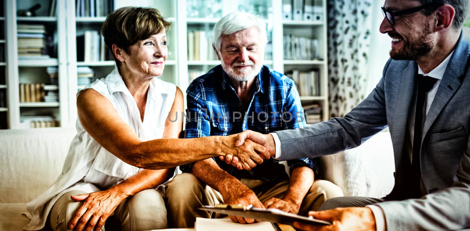 Smiling financial advisor shaking hands with senior woman by Wavebreakmedia