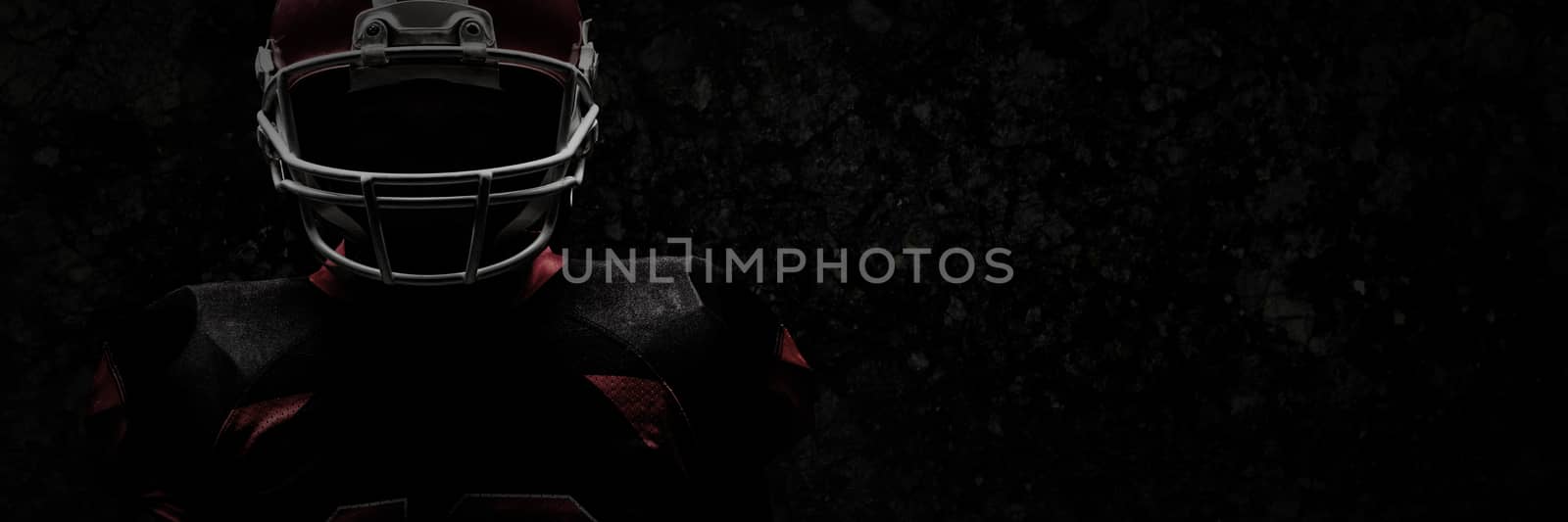 American football player standing in rugby helmet against old weathered wall