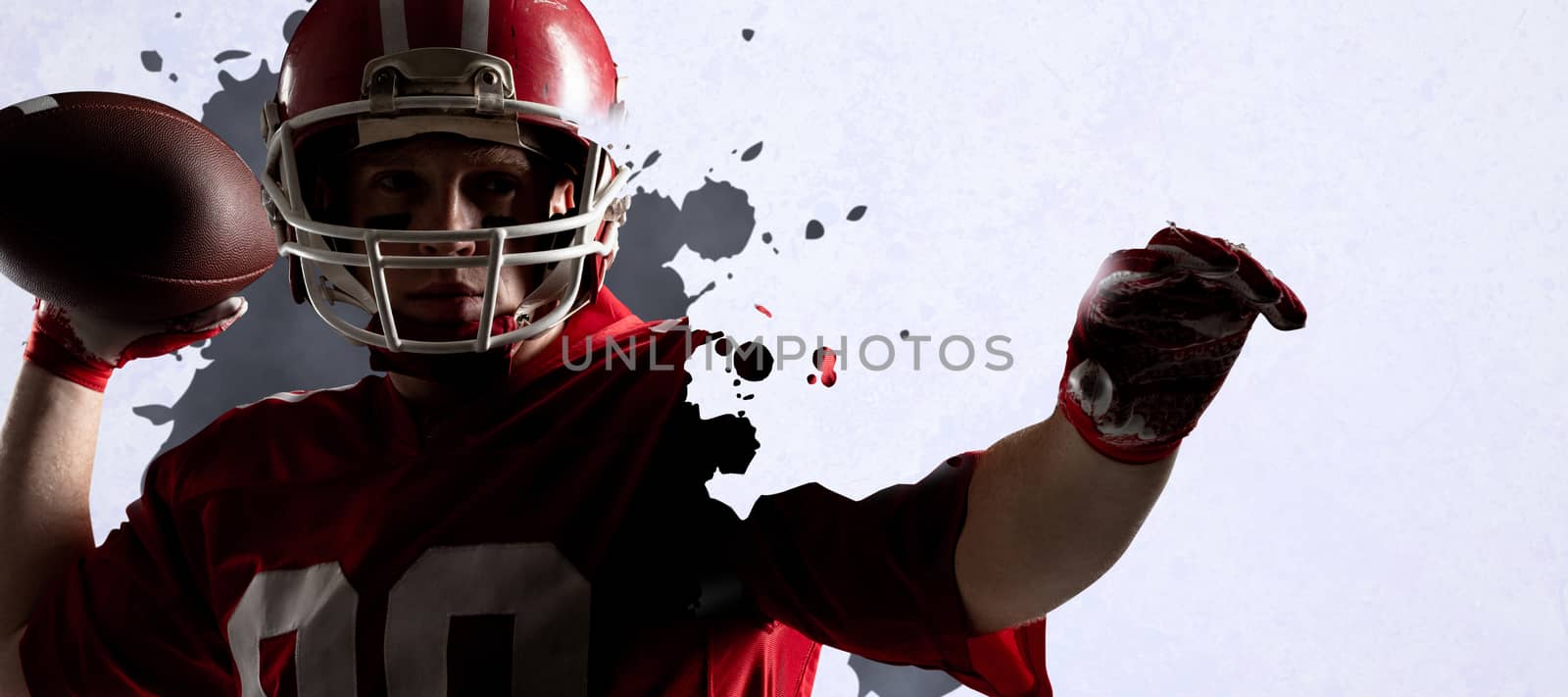 American football player standing with helmet preparing to throw ball against grey vignette