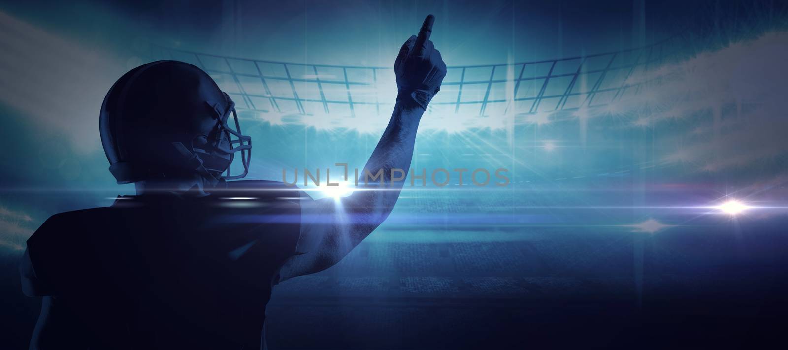 American football player in helmet pointing upwards against american football arena
