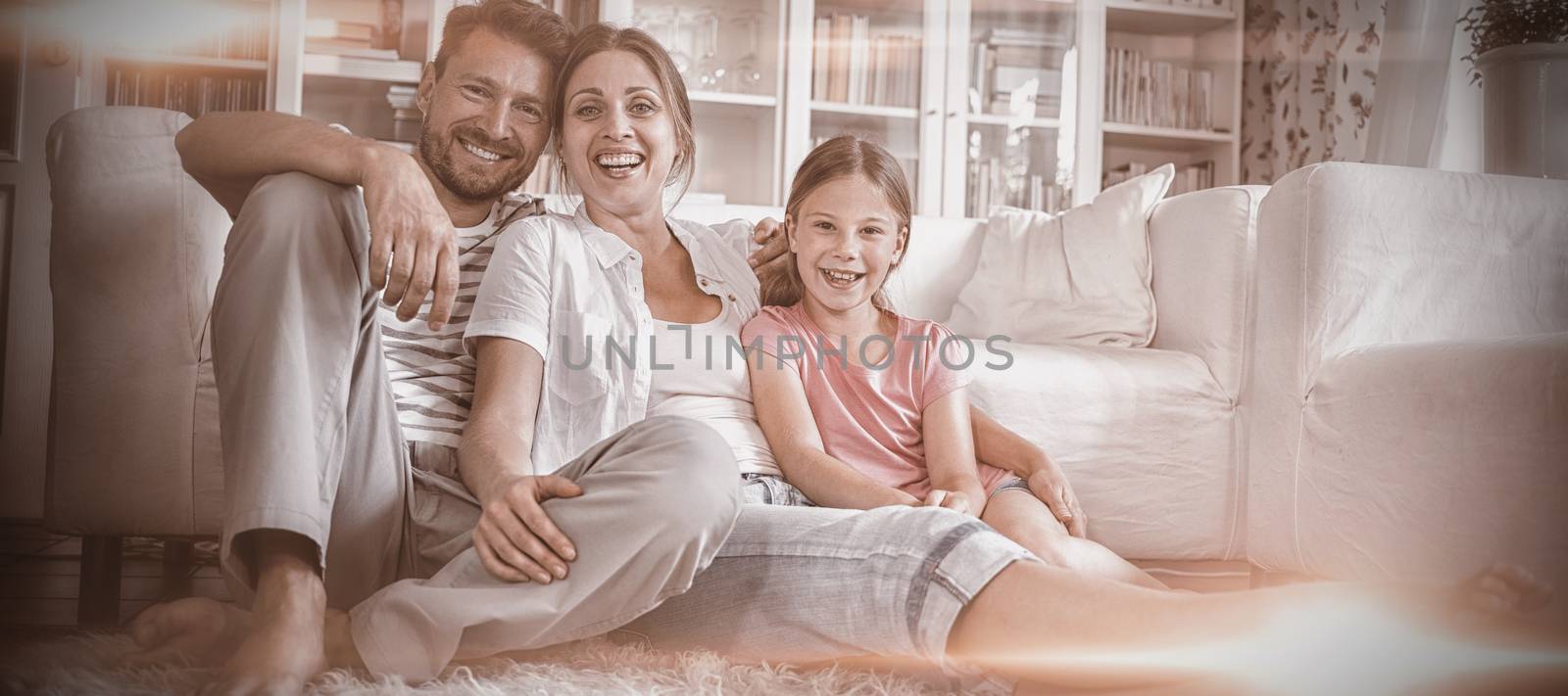 Happy family sitting on rug in living room at home