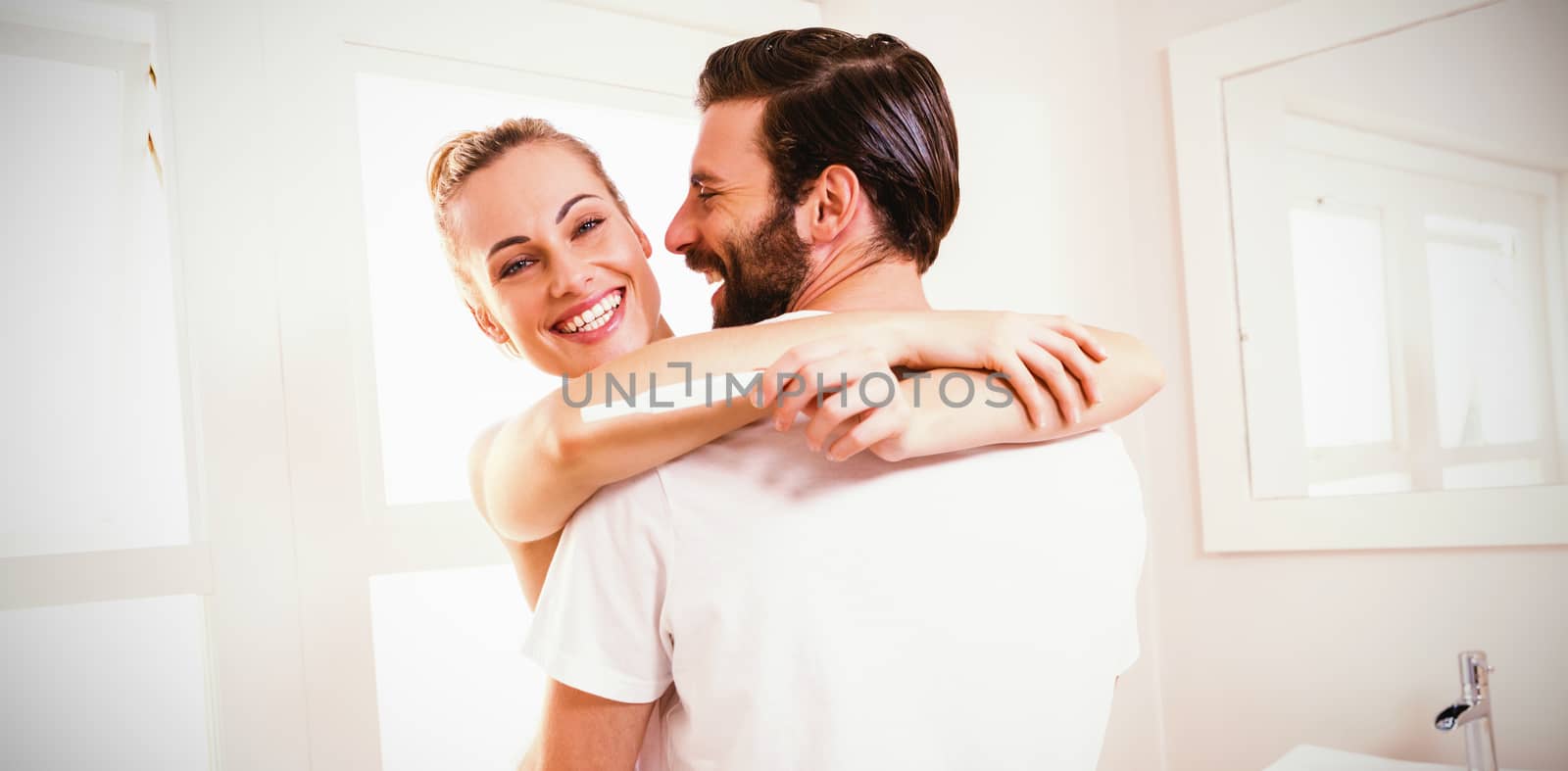 Woman holding pregnancy test while embracing man at home