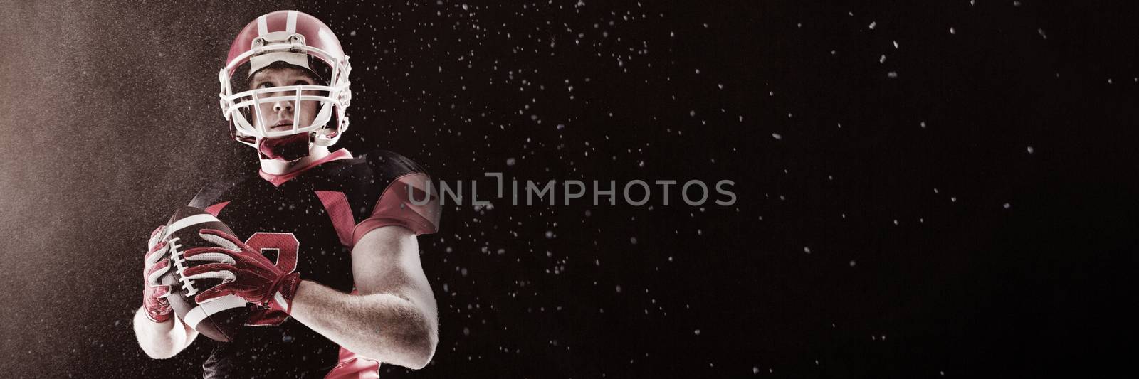 Splashing of powder against american football player in helmet holding rugby ball