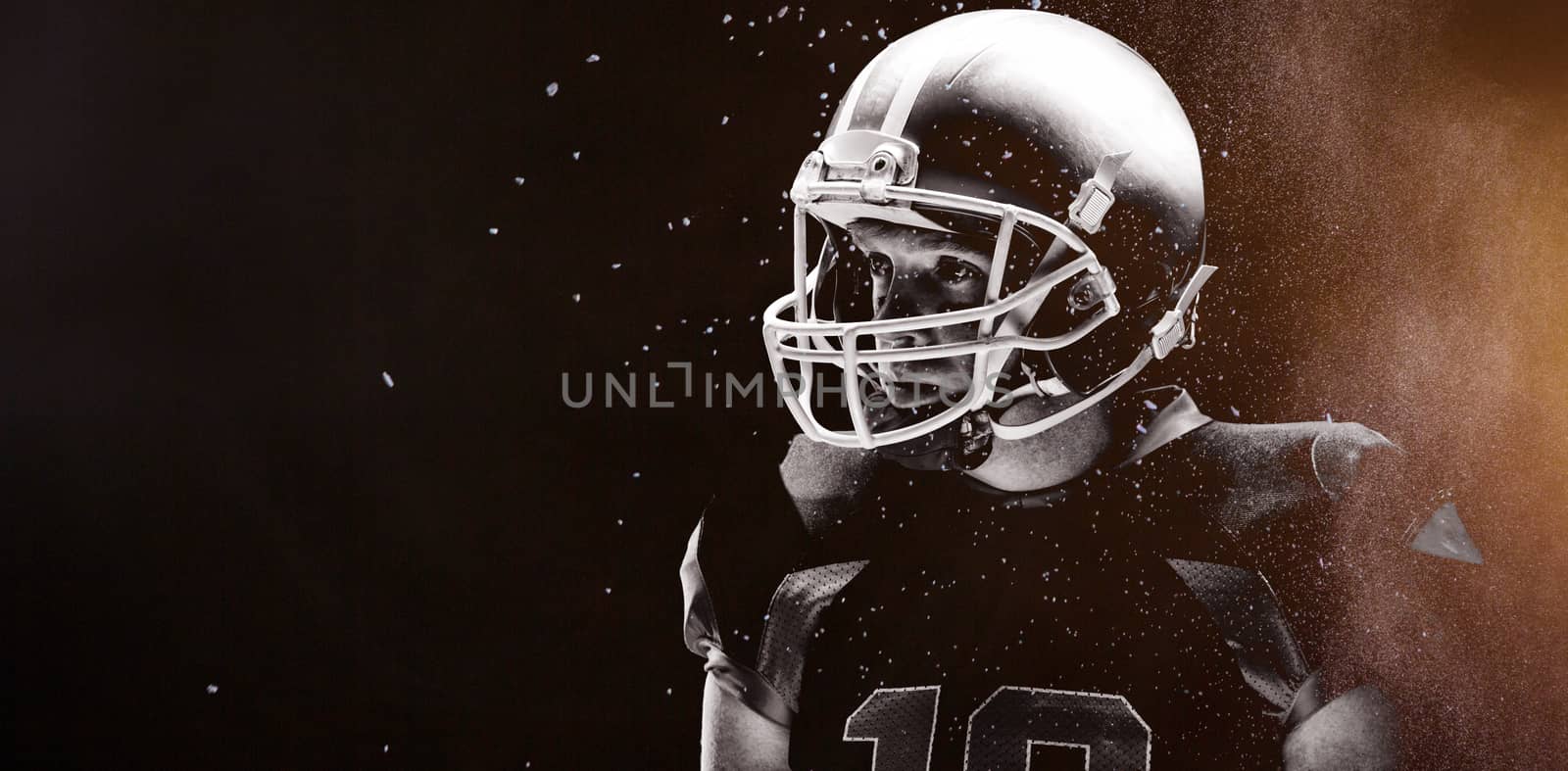 Digitally generated image of powder against american football player standing with rugby helmet