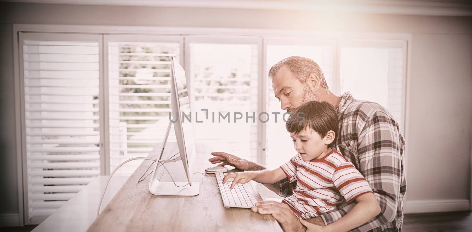 Father and son working on computer by Wavebreakmedia