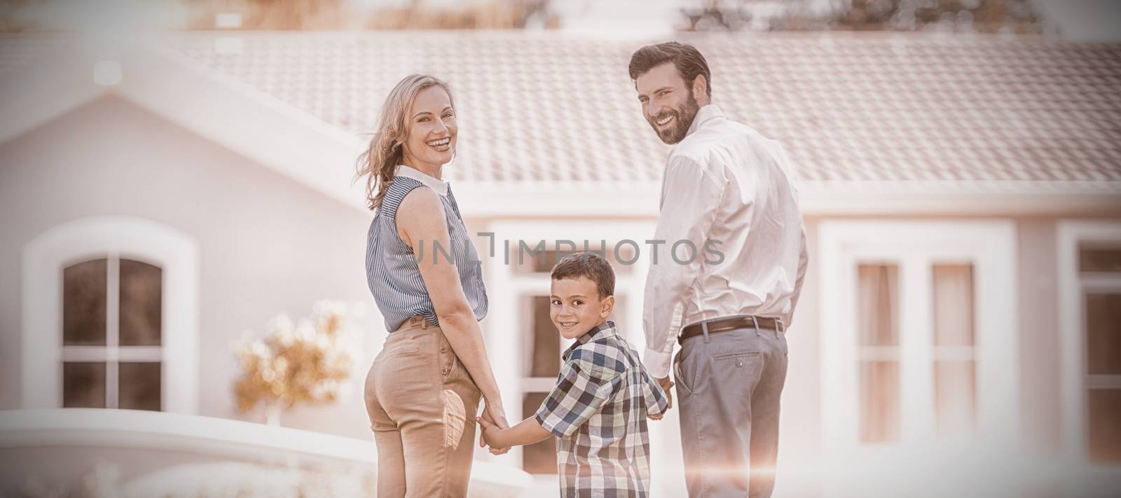 Parents and son standing in garden by Wavebreakmedia