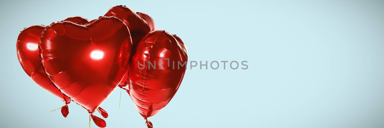 Red heart shape balloons against blue background