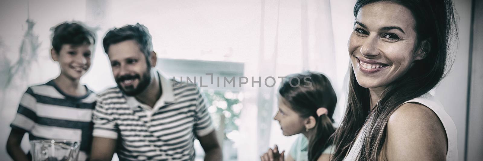 Portrait of happy woman sitting at breakfast table with her family