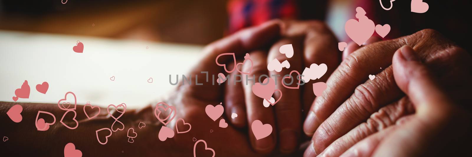 Valentines heart design against senior couple holding hands