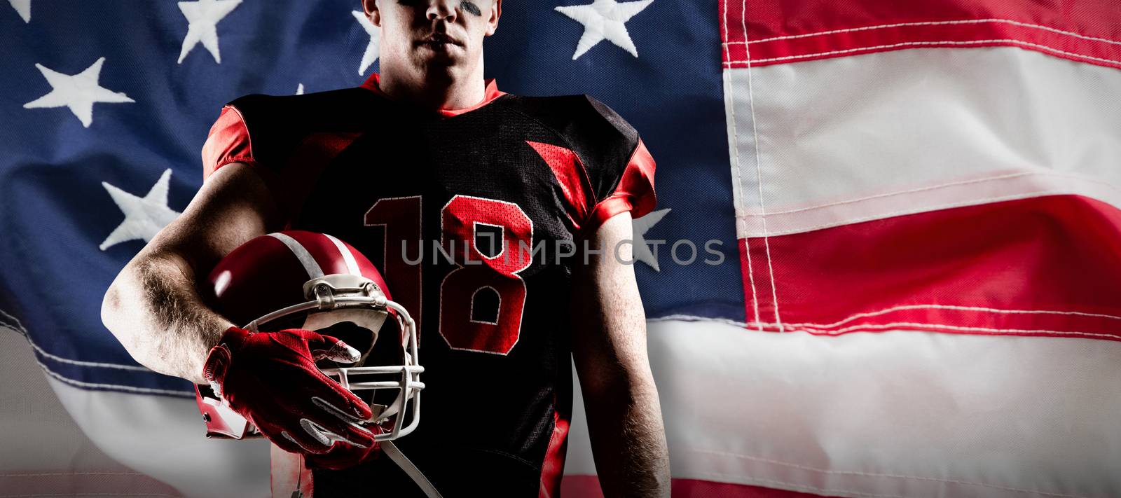 American football player holding rugby helmet against full frame of american flag
