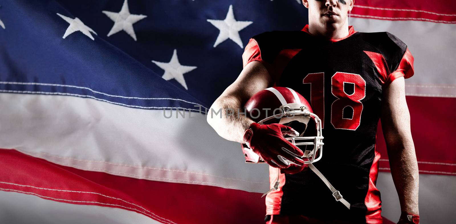 American football player standing with helmet  against close-up of an american flag