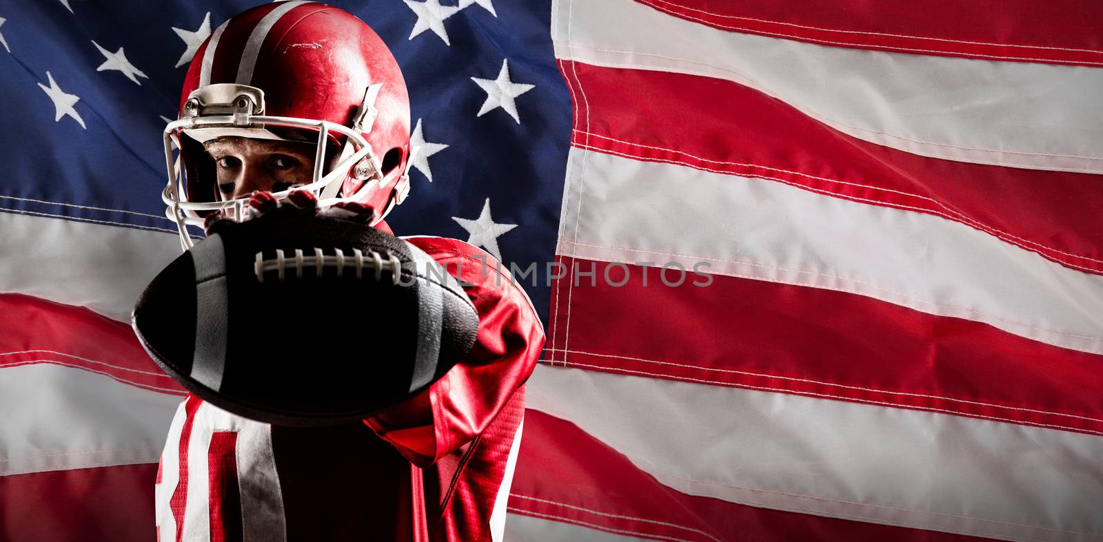 Composite image of american football player holding rugby ball by Wavebreakmedia