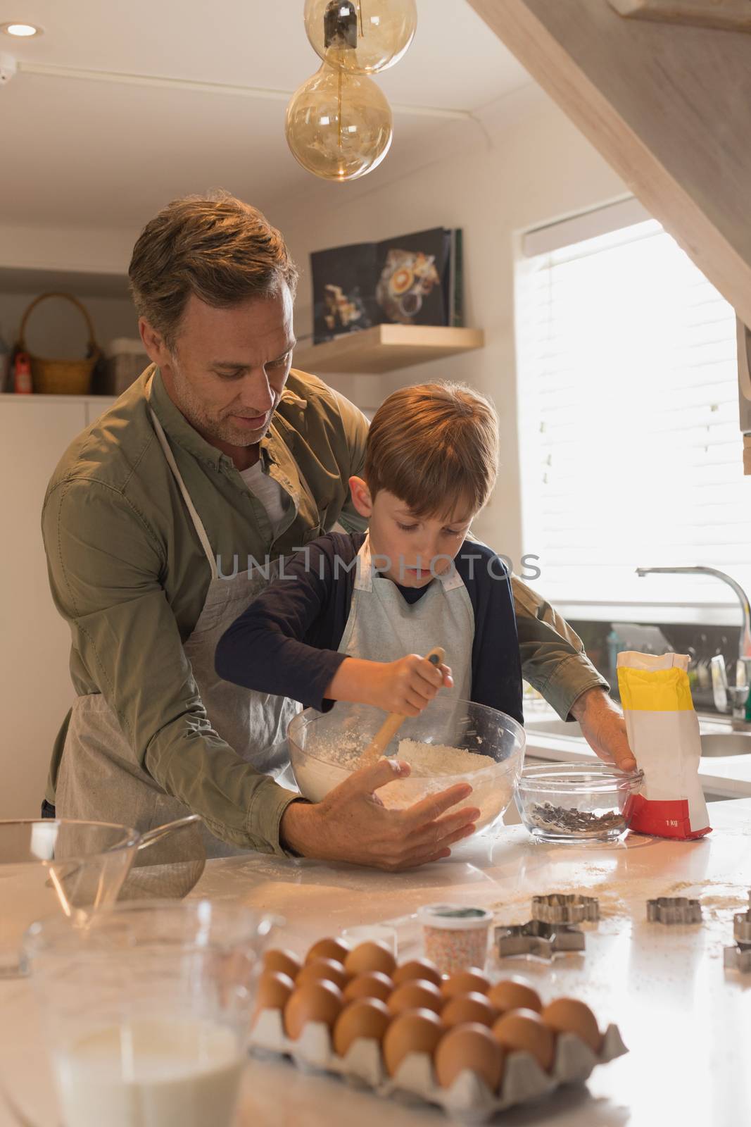 Father with his son preparing food in kitchen by Wavebreakmedia