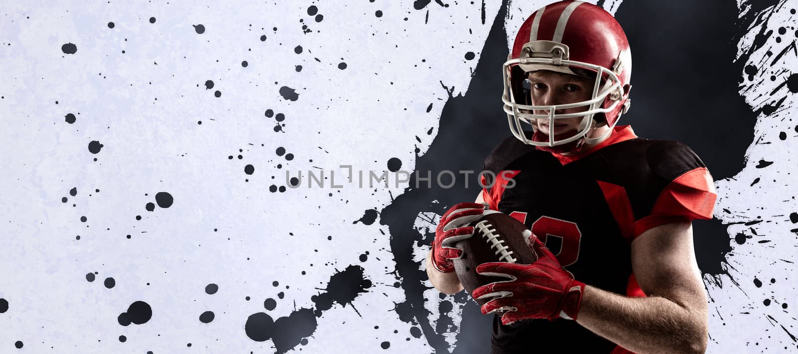 American football player in helmet holding rugby ball against grey vignette