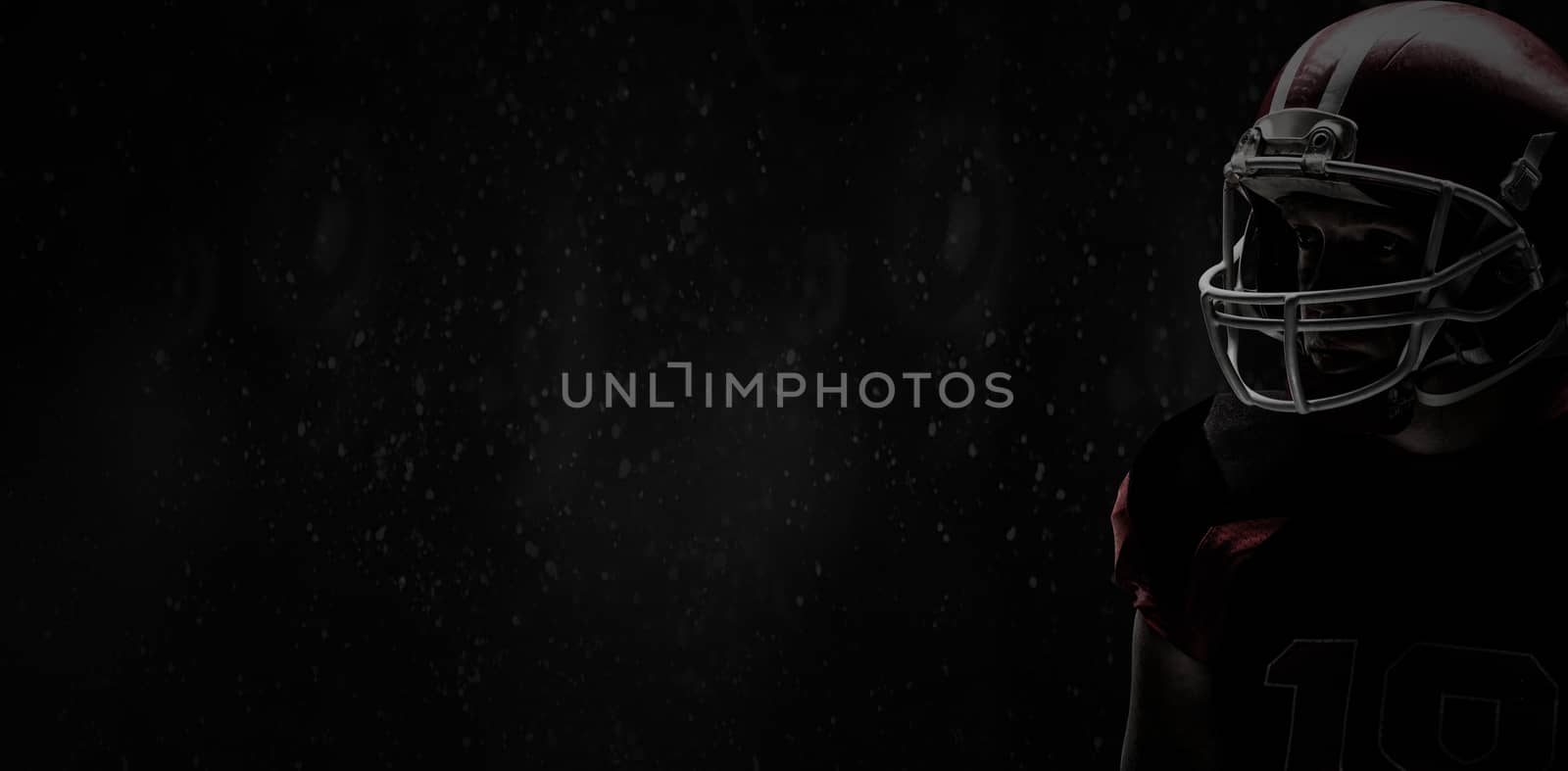 American football player standing in rugby helmet against full frame shot of wall