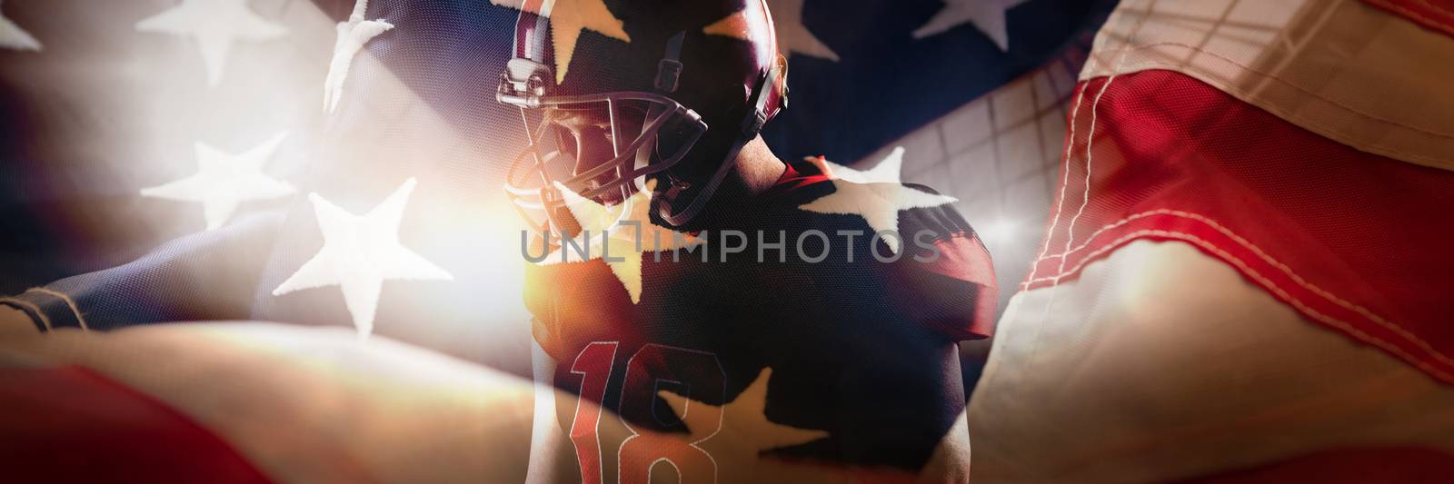 American football player standing in helmet against full frame of american flag