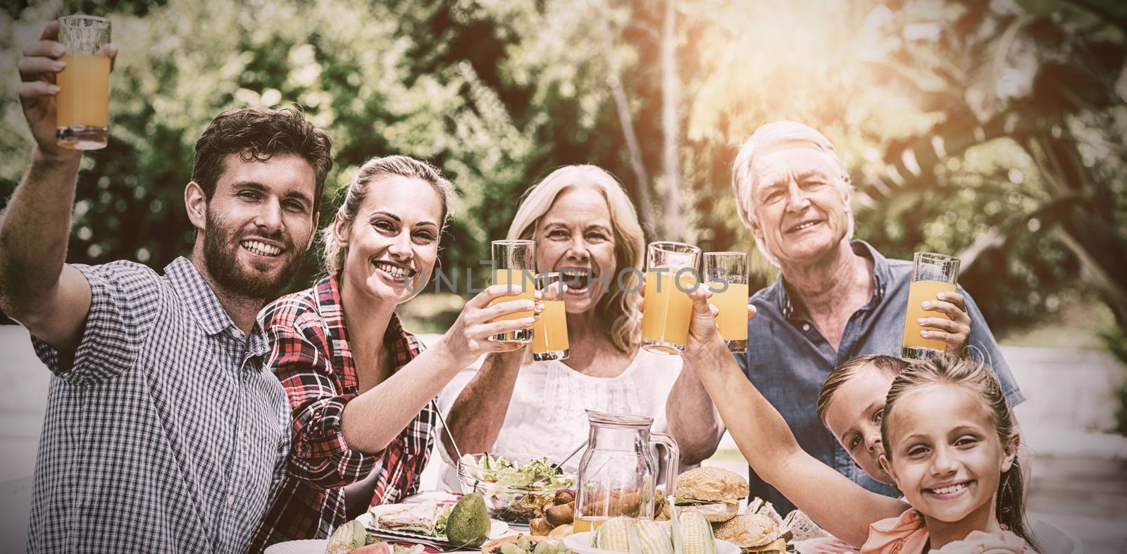 Happy family having breakfast at table in yard 