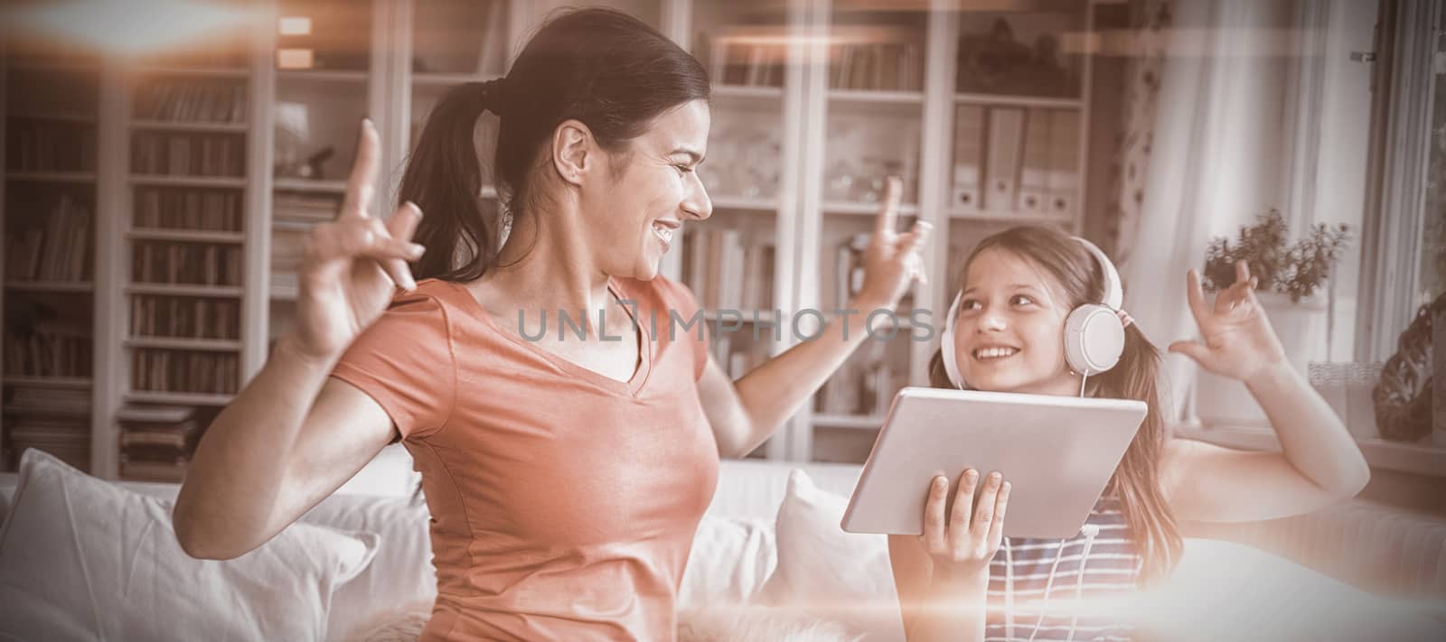 Happy mother and daughter using digital tablet and dancing by Wavebreakmedia