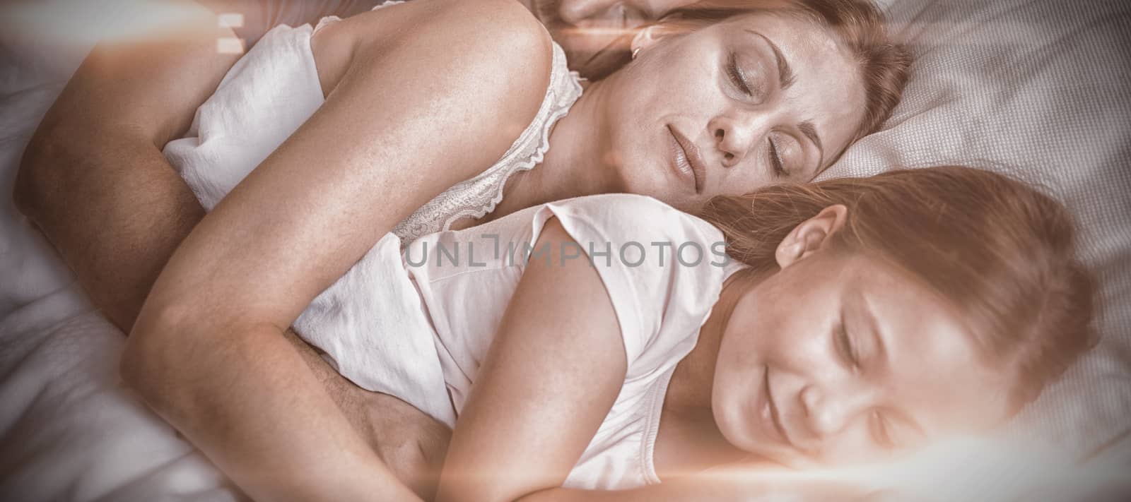 High angle view of little daughter sleeping with parents at home