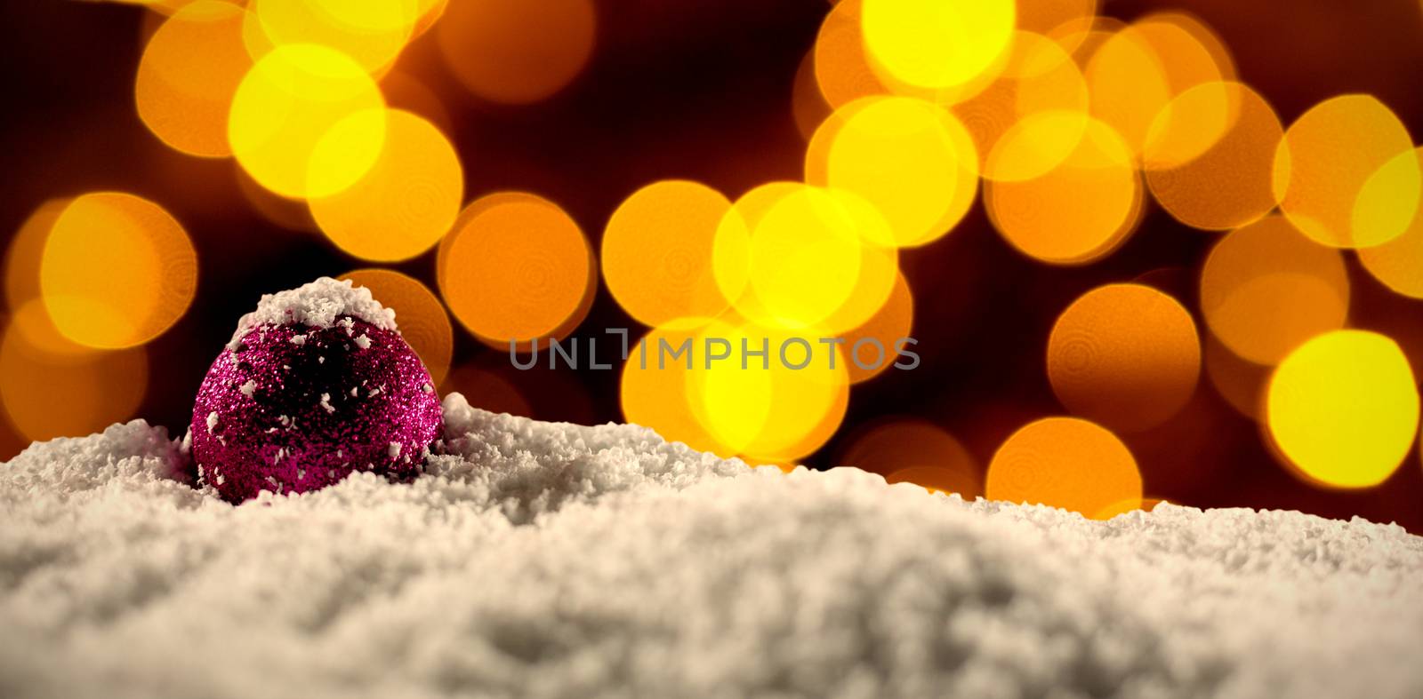 Christmas balls with an electric garland while snowing against unfocused christmas light