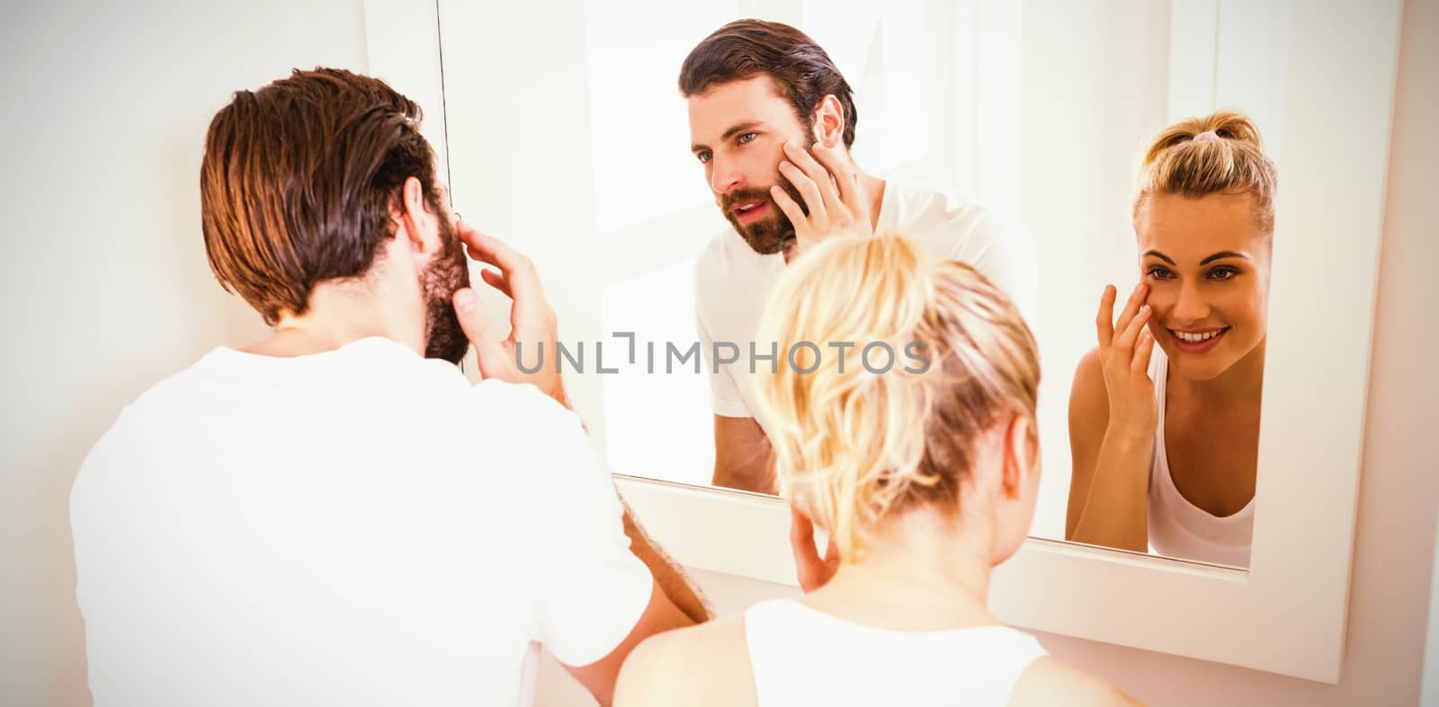 Couple checking their skin in bathroom at home
