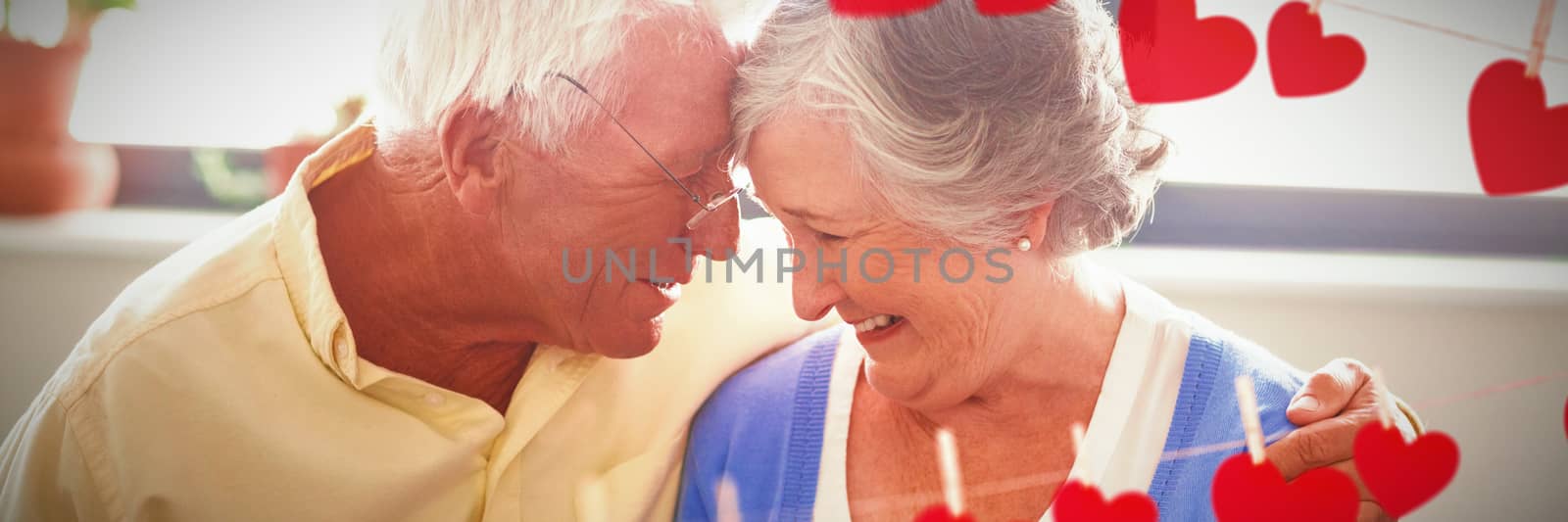 Hearts hanging on a line against senior couple hugging each other