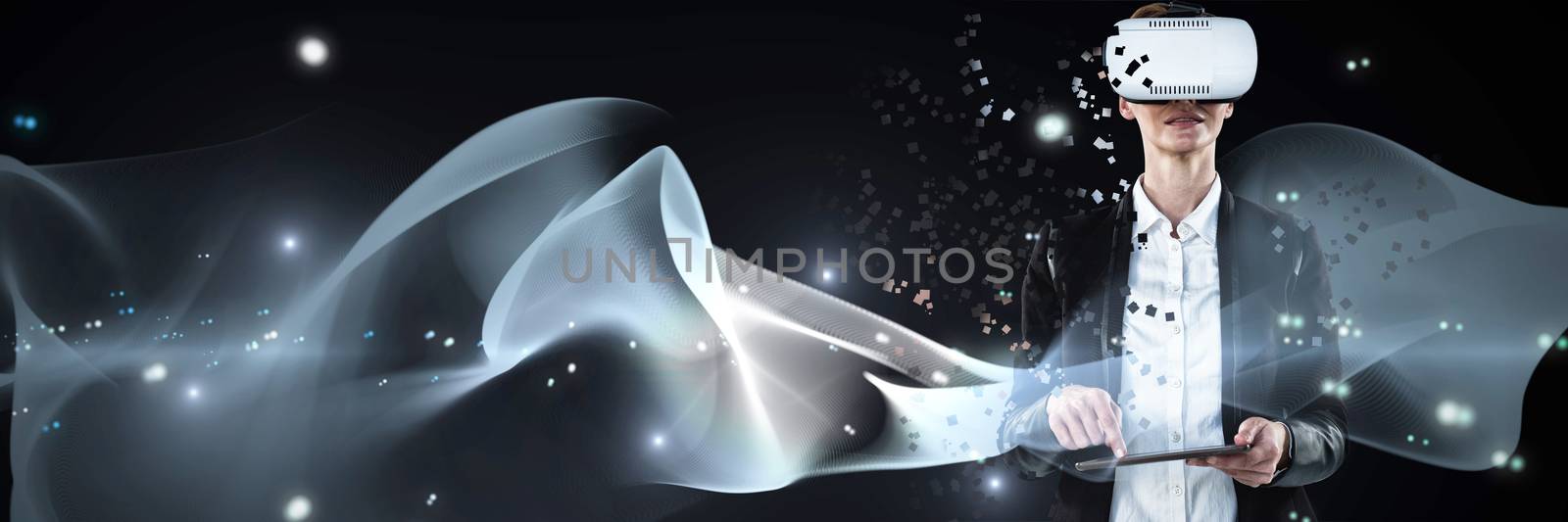 Businesswoman working with VR while using tablet against abstract glowing black background