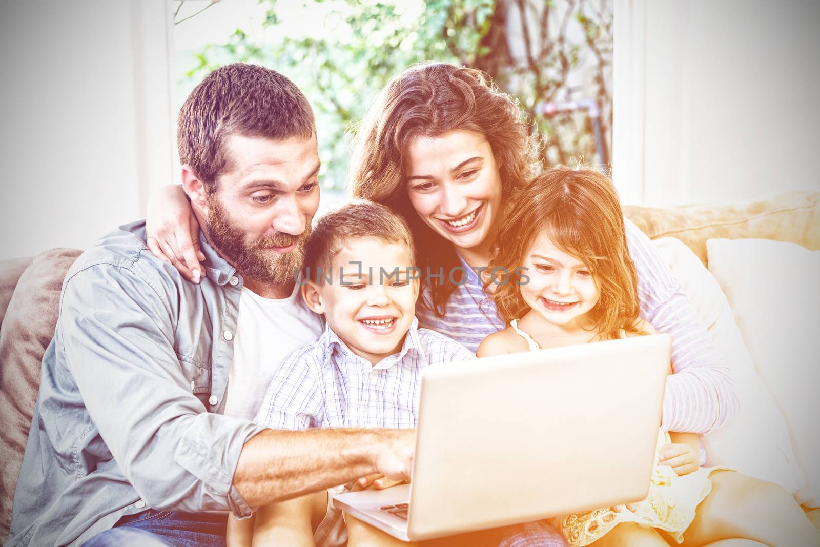 Smiling family with laptop by Wavebreakmedia