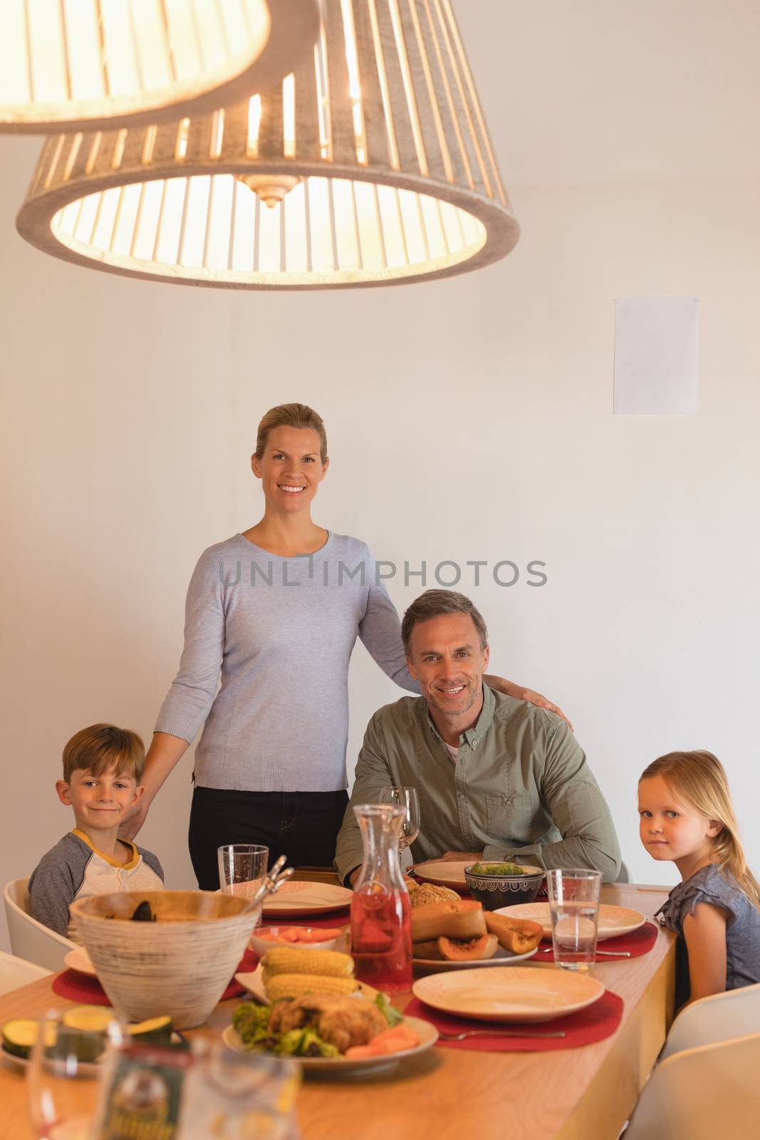 Portrait of happy family sitting on dining table at home