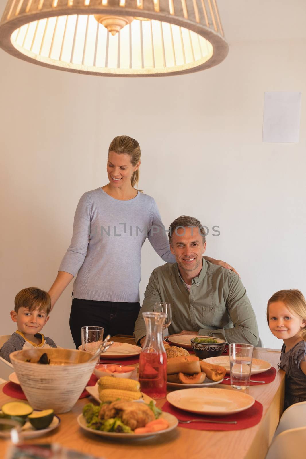 Portrait of happy family sitting on dining table at home