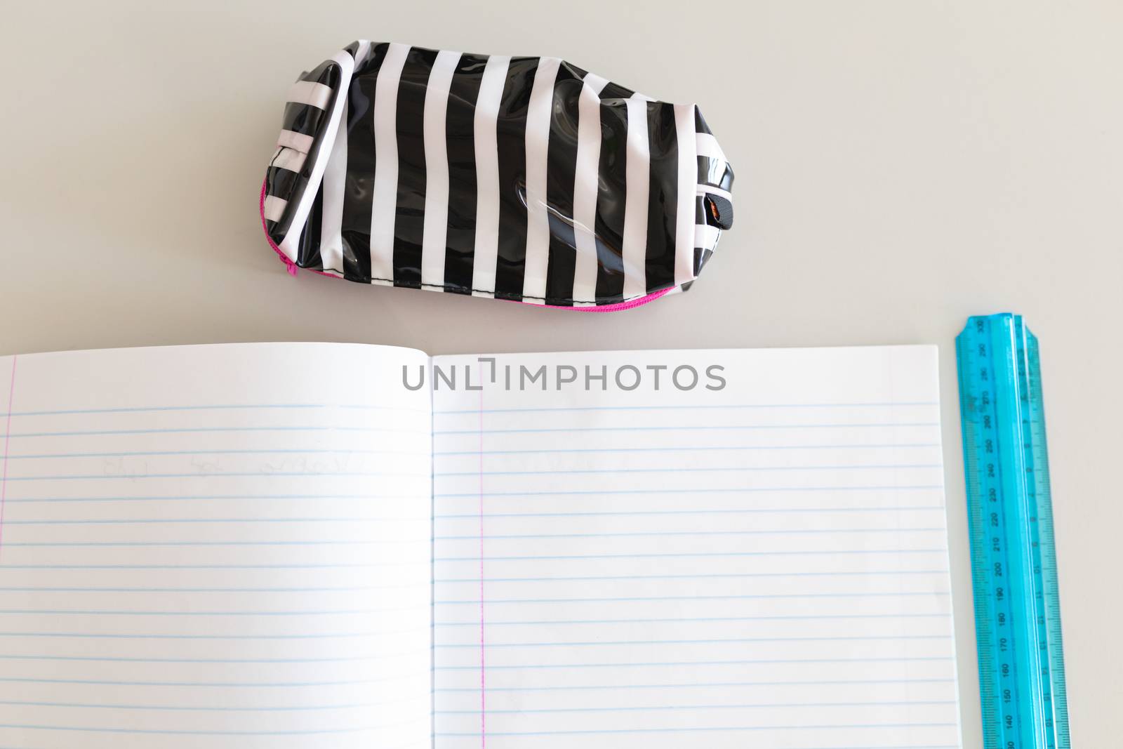 Close-up of notebook, ruler and pencil case on the desk in school