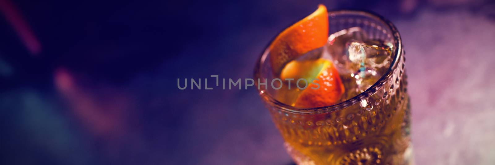 Close up of orange cocktail in glass at counter in bar