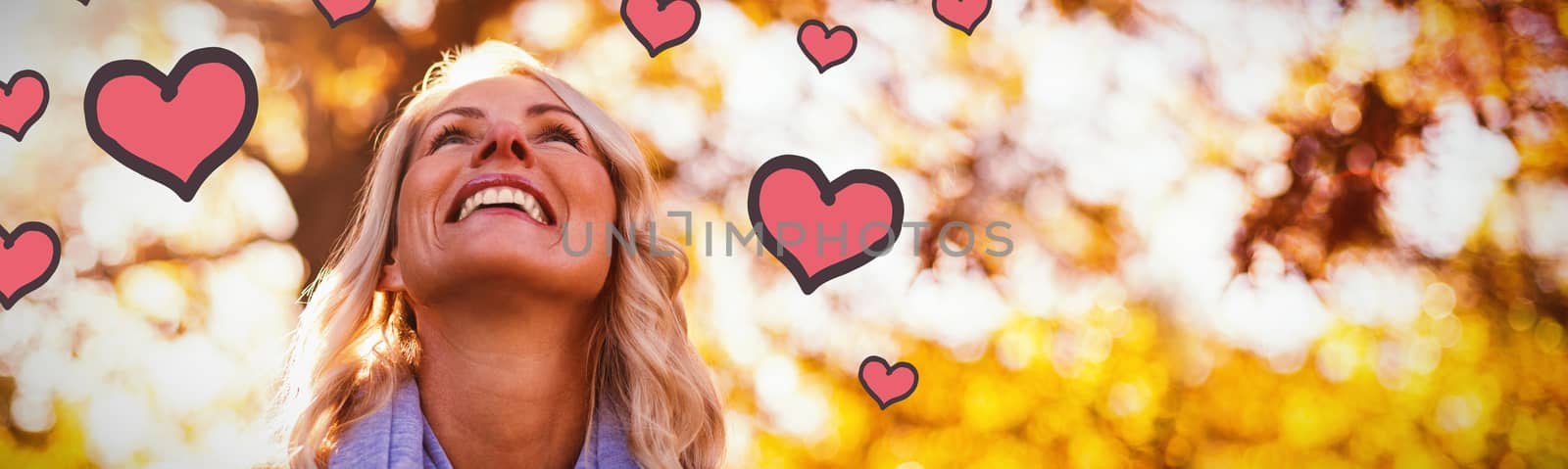 Red Hearts against smiling woman looking up against trees