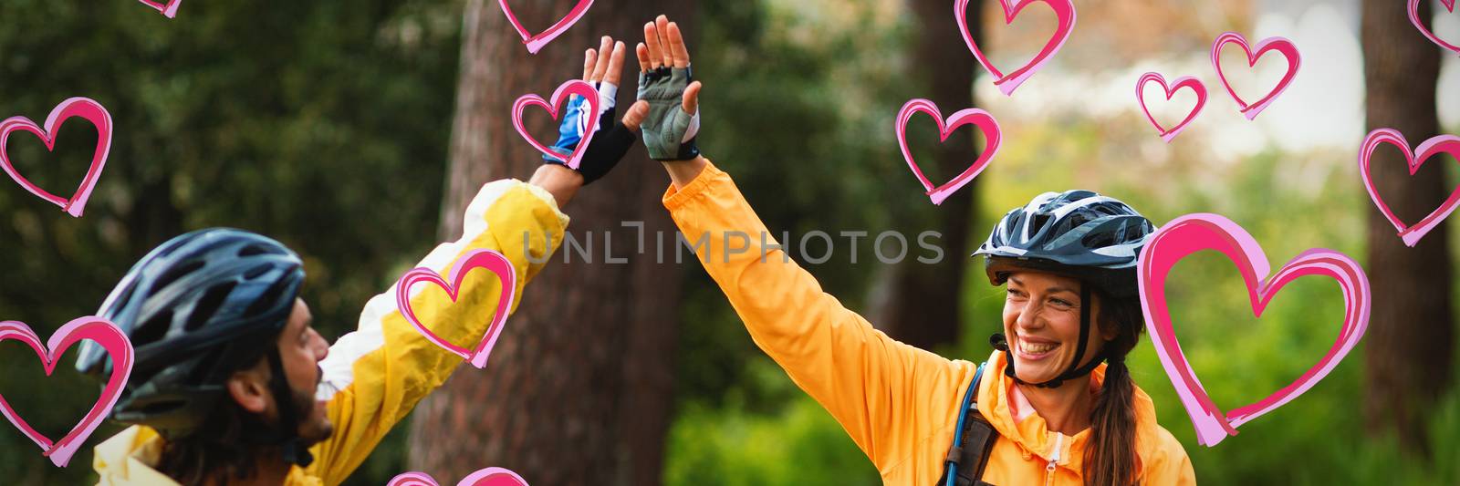 Red Hearts against biker couple giving high five to each other in countryside