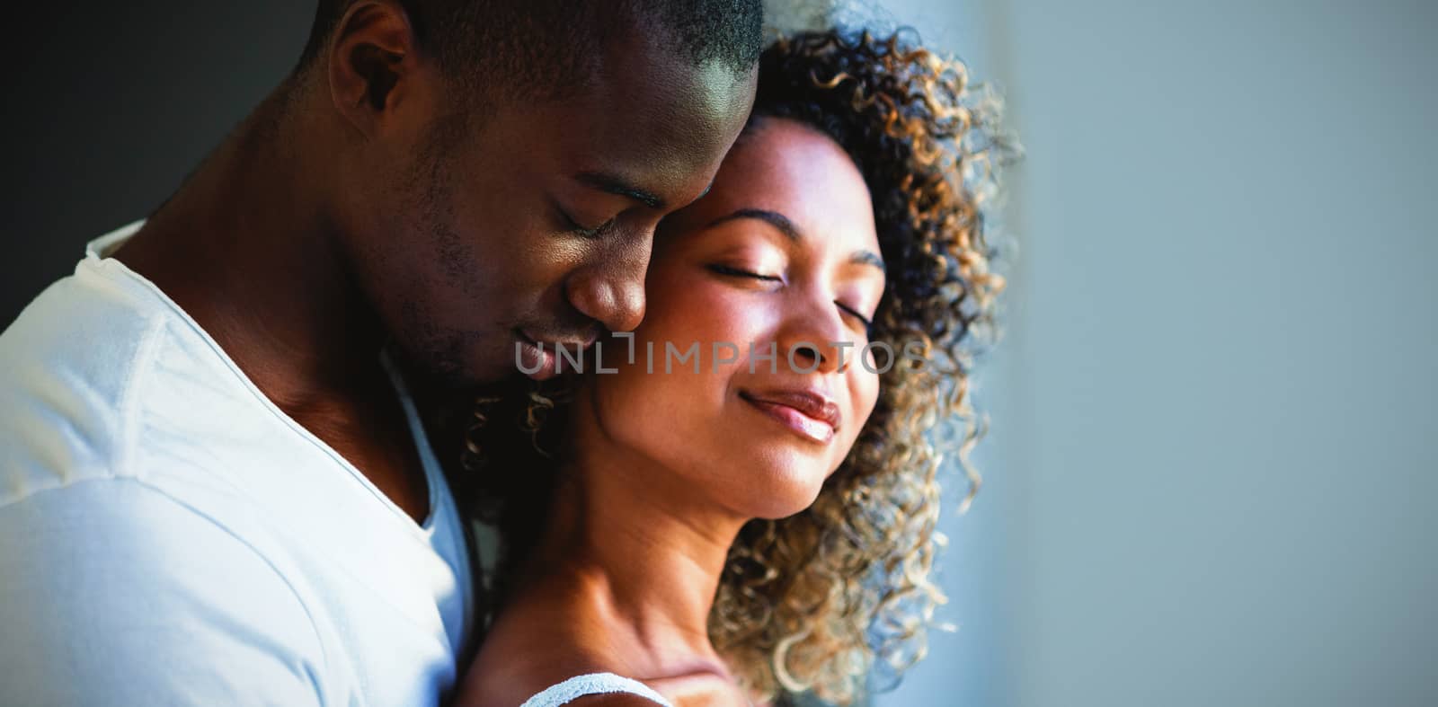 Young couple embracing together at home