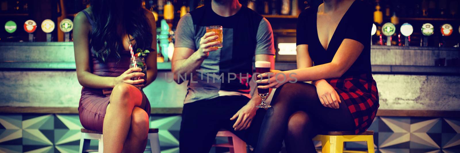 Friends enjoying the drinks at counter in bar