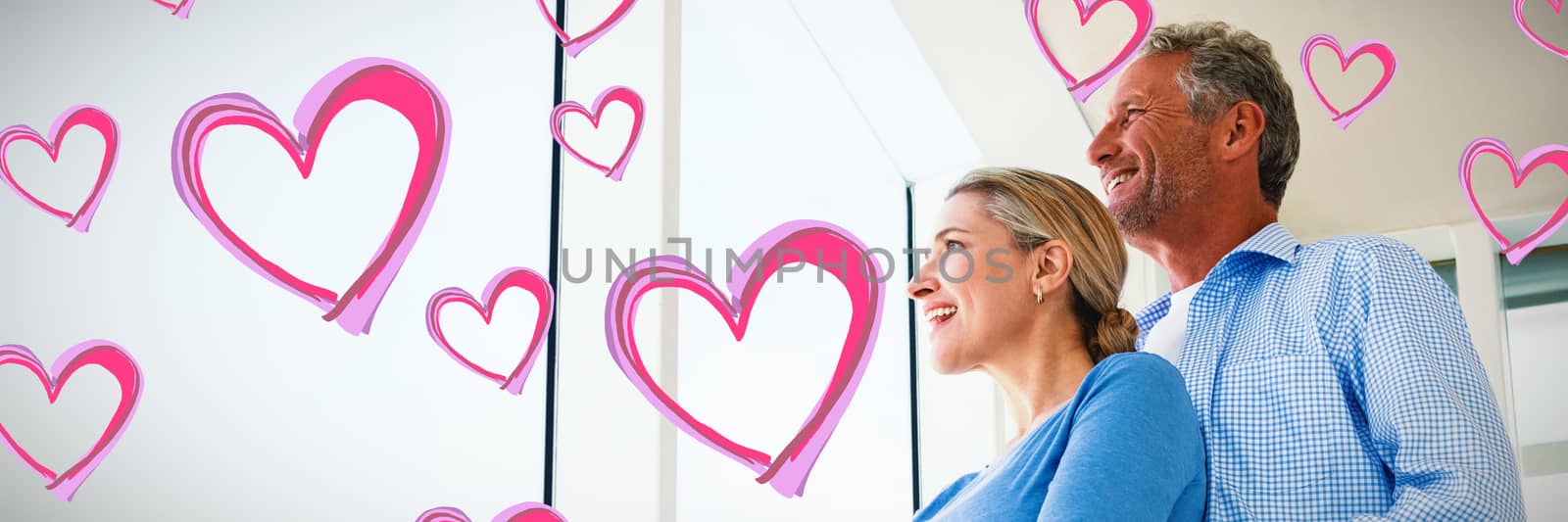 Red Hearts against couple looking through window at home