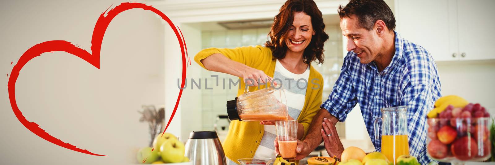 Heart against happy couple preparing smoothie in kitchen